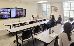 Wide shot of the Henderson conference room with Open House attendees.