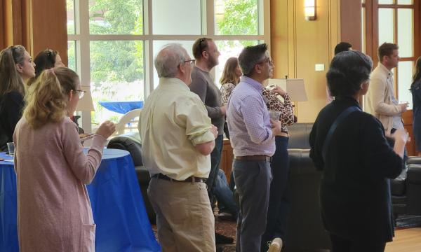 Group shot of SSRI cofund faculty members listening to Deb Ehrenthal, SSRI Director present.