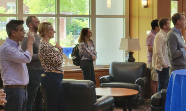 Group shot of SSRI cofunded faculty members listening to Deb Ehrenthal, SSRI Director present.