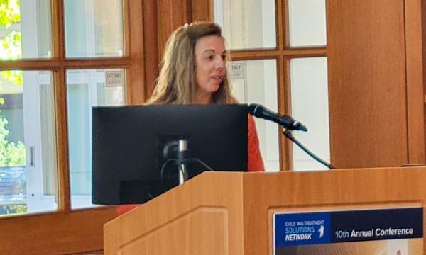 Jacki Hoover presents at the podium.
