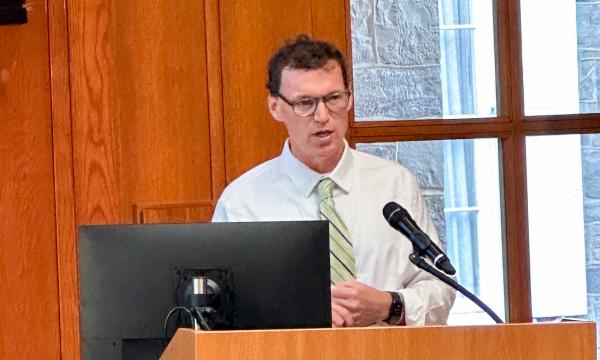 Joseph Ryan presents at the podium.