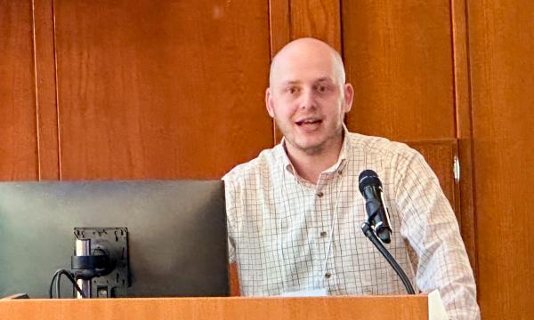 Ezra Goldstein presents at the podium.