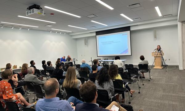 Photo of Emily Pakhtigian presenting to attendees of the De Jong Lecture.