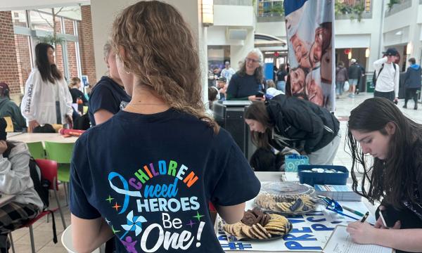 A student with long hair models the t-shirt for the event.