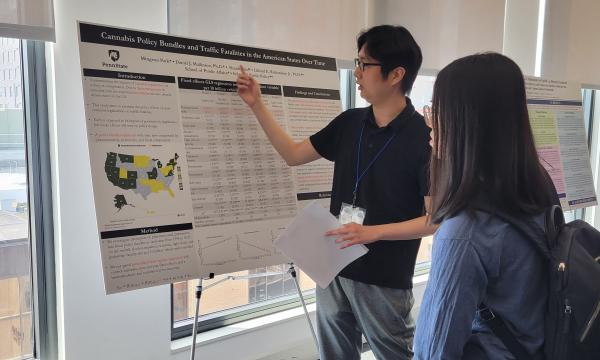 Mingean Park explains his poster to another student.