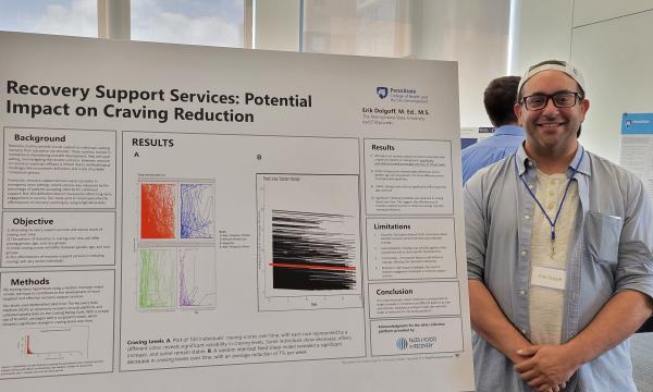 Erik Dolgoff stands next to his poster.