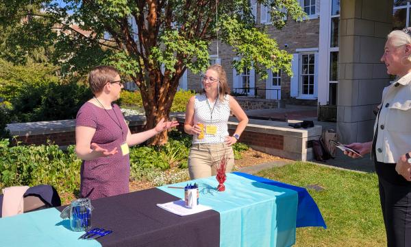 The Office of Research Protections table chats with attendees.