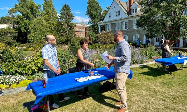 Attendees mingling outside on the Alumni Hall lawn.