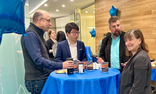 Attendees at the SSRI Open House chatting at a high-top table.