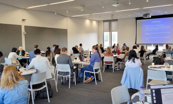 Close-up shot of the conference attendees sitting down at round tables.