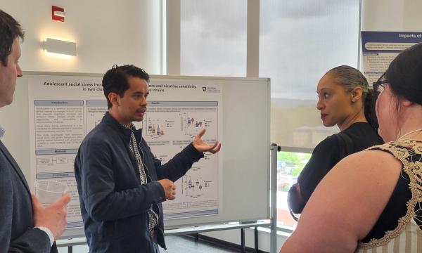 Presenters from the Poster Session show off their posters.
