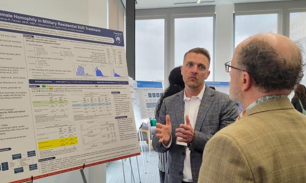 Presenters from the Poster Session show off their posters.