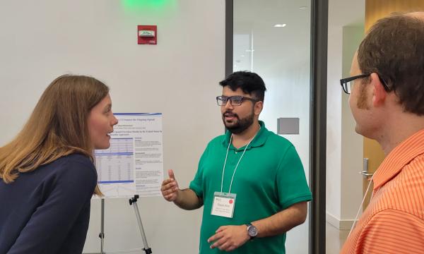 Presenters from the Poster Session show off their posters.