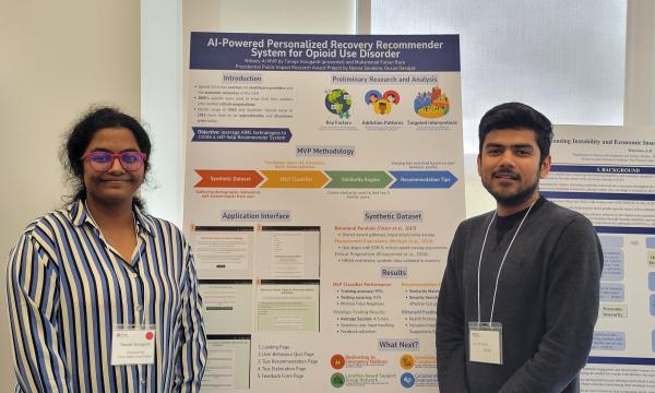 Presenters from the Poster Session show off their posters.