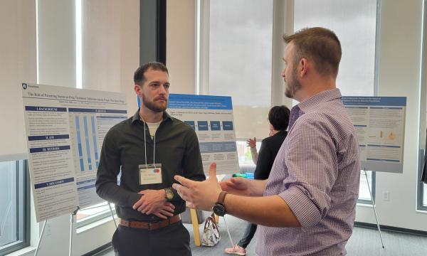 Presenters from the Poster Session show off their posters.