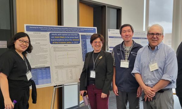 Presenters from the Poster Session show off their posters.