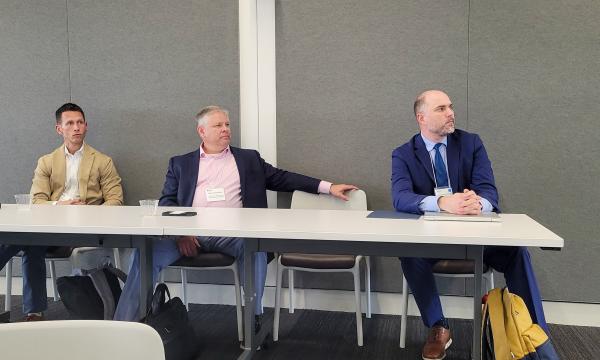 Glenn Sterner, Dennis Scalon and Jonathan Larsen listen to Kristina Brant present.